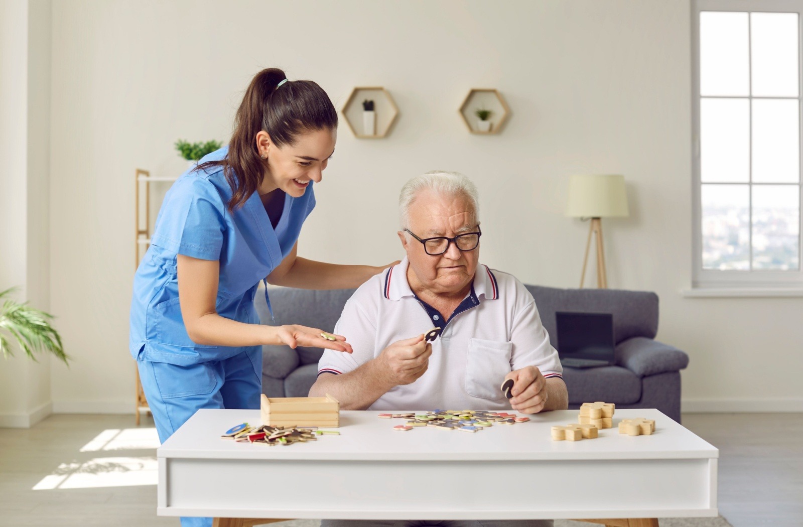 A memory care resident engages with a cognitive stimulation activity, as a caregiver guides them
