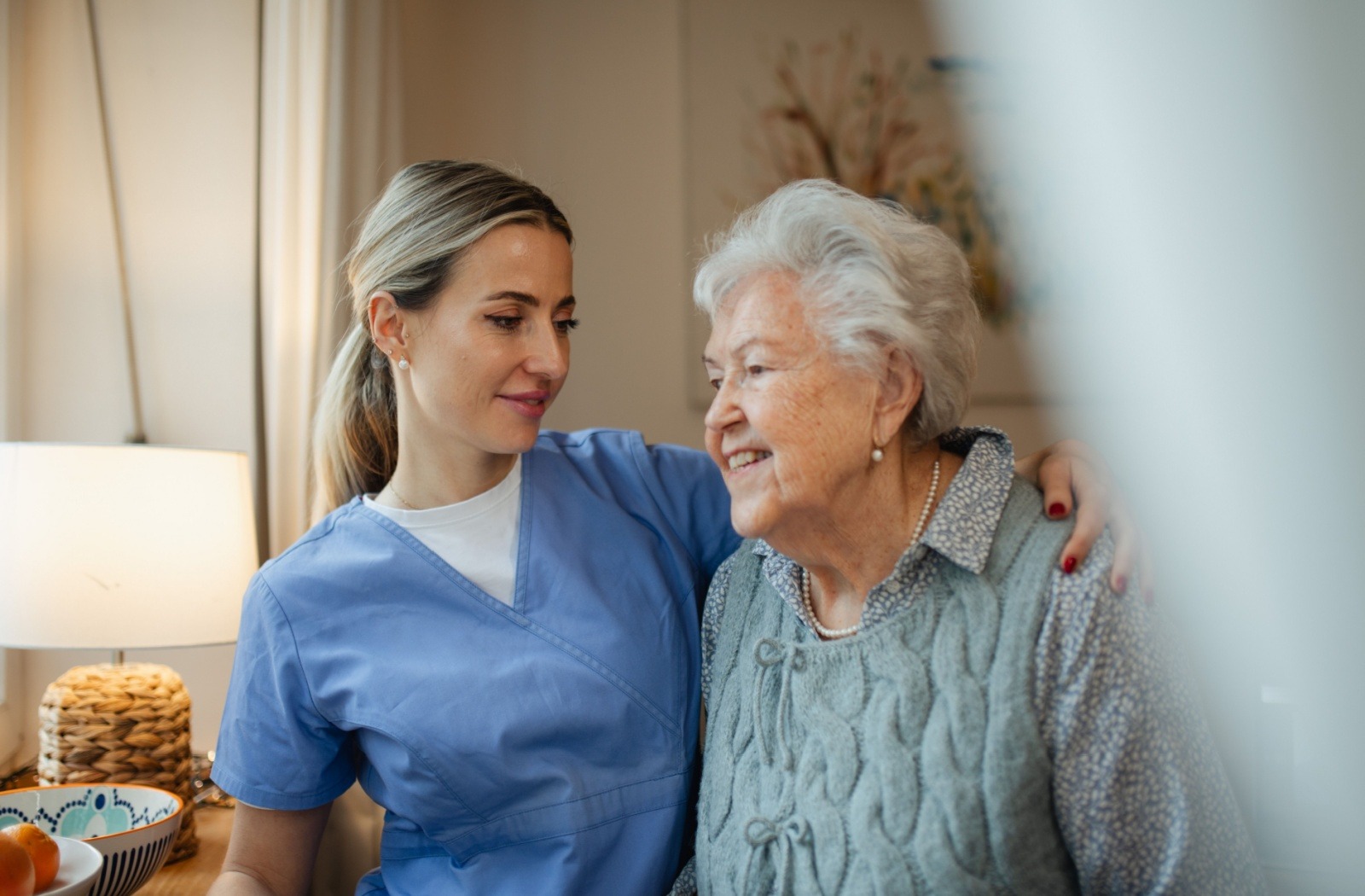 A caregiver places their arm around a senior resident.

